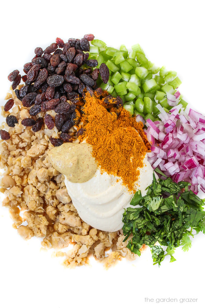 Ingredients for curried chickpea salad in a glass bowl before mixing together