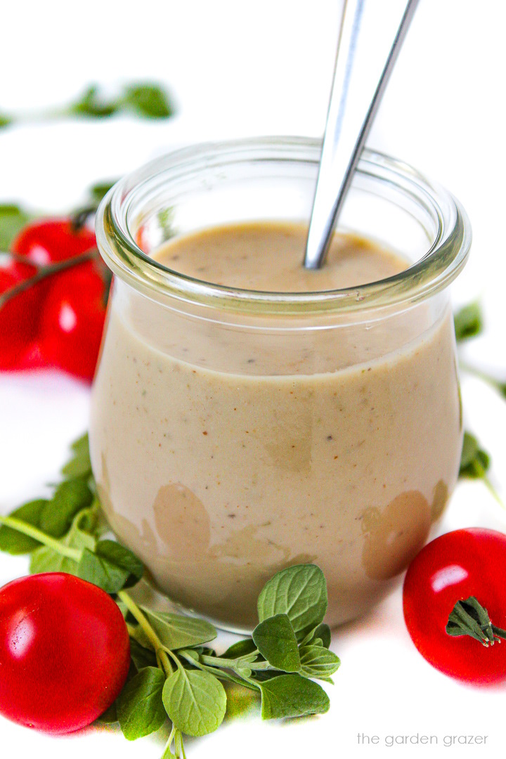 Oil-free vegan Greek Dressing in a small glass jar with serving spoon