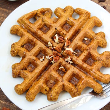 Vegan pumpkin waffle on a white plate with fork