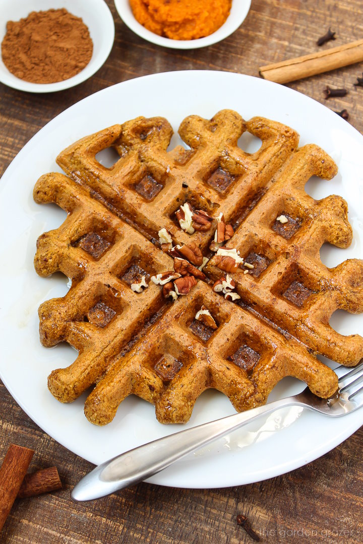 Vegan pumpkin waffle on a white plate with fork