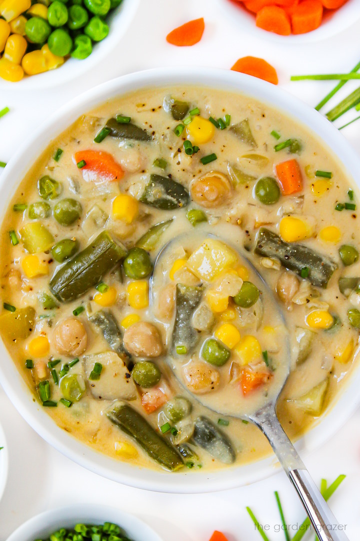 Close up view of vegan creamy vegetable chowder in a white bowl