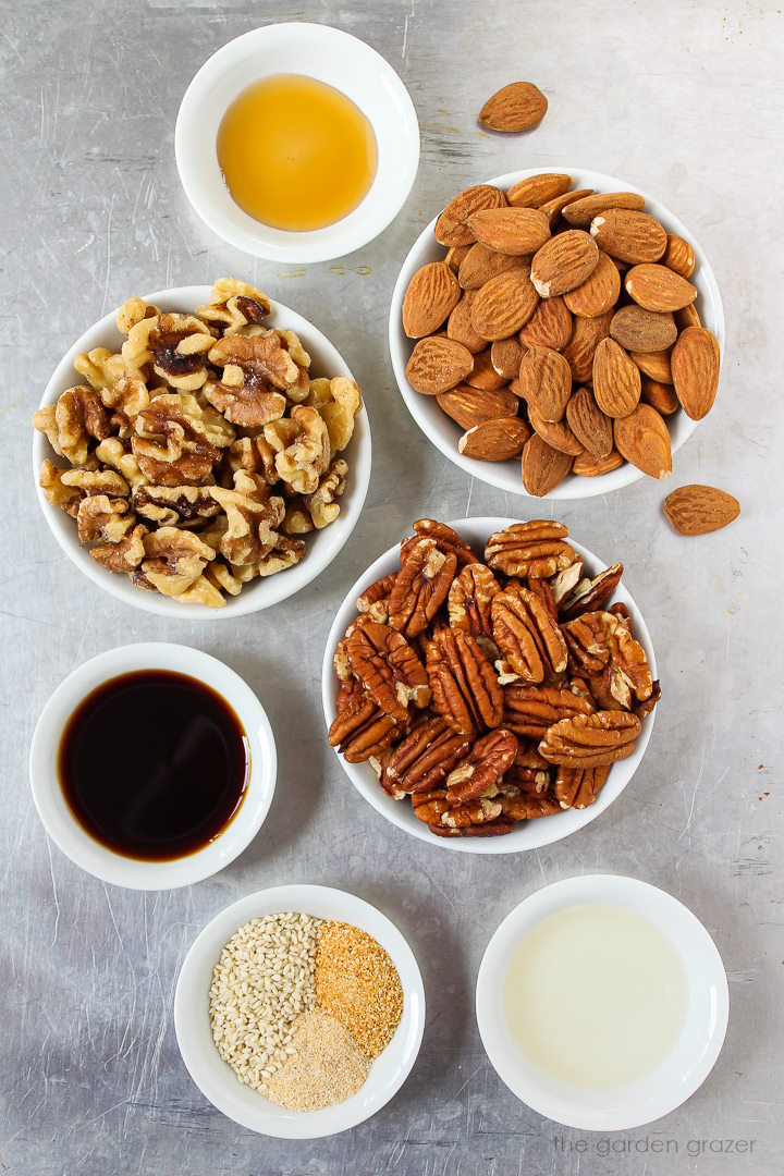 Raw walnuts, almonds, pecans, tamari, vinegar, and spice ingredients laid out on a metal tray
