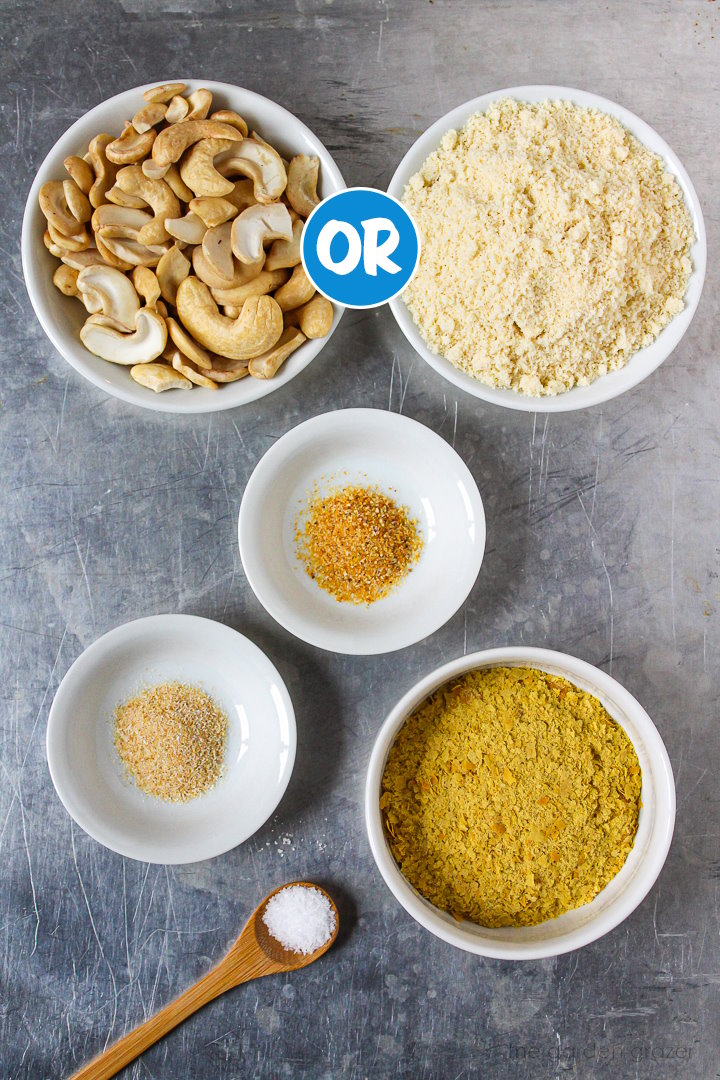 Cashews, almond flour, nutritional yeast, and spice ingredients laid out in white bowls on a metal tray