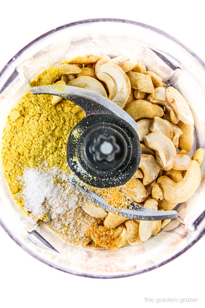 Overhead view of ingredients for vegan parmesan cashew cheese in a small food processor before blending