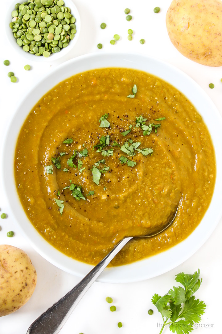 Overhead view of vegan split pea soup in a white bowl with spoon