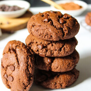 A stack of baked vegan chocolate cookies on a white table
