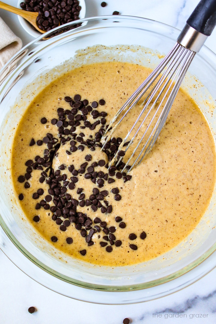 Overhead view of whisking together muffin batter in a large glass bowl