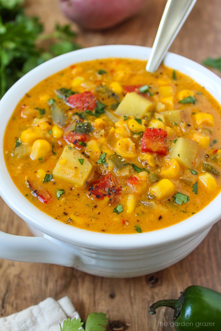Vegan southwest corn chowder in a white soup bowl garnished with fresh cilantro