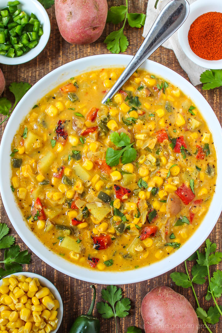 Close-up view of southwest corn potato chowder in a white bowl with serving spoon