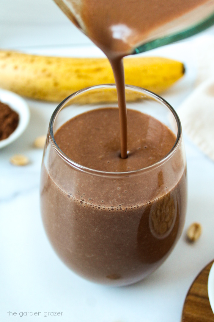 Chunky monkey smoothie being poured into a serving glass