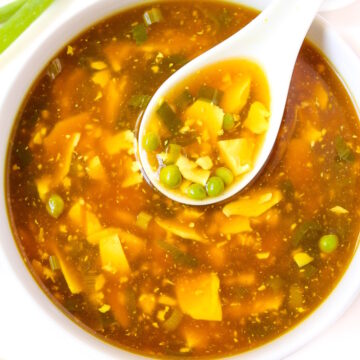 Vegan egg drop soup with serving spoon in a white bowl