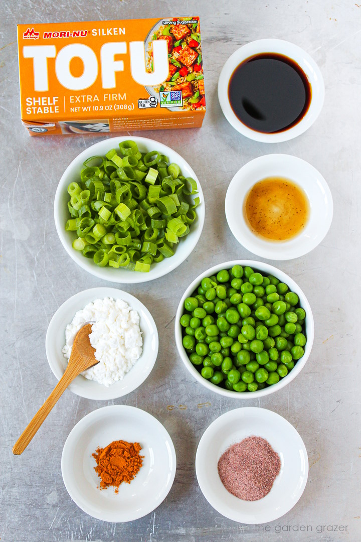 Silken tofu, peas, tamari, green onions, cornstarch, and seasoning ingredients laid out on a metal tray