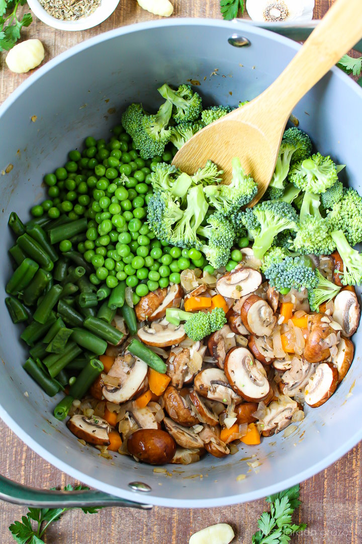 Overhead view of preparing soup ingredients in a large pot before mixing together