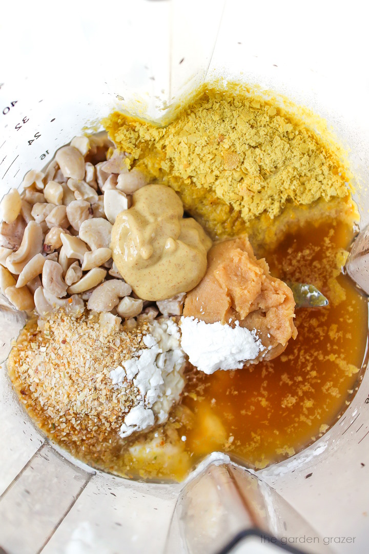 Overhead view of preparing cashew alfredo sauce ingredients in a blender before blending
