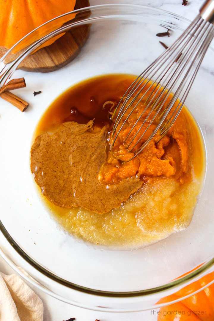 Overhead view of wet ingredients in a large mixing bowl with whisk