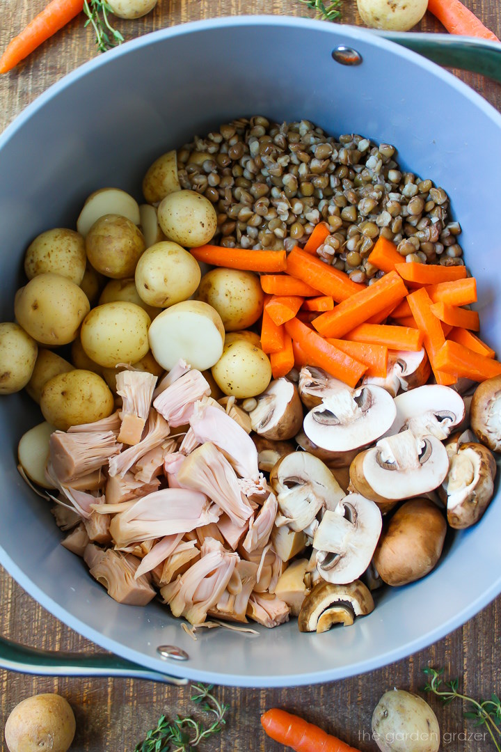 Overhead view of preparing vegan pot roast ingredients in a large pot before mixing together