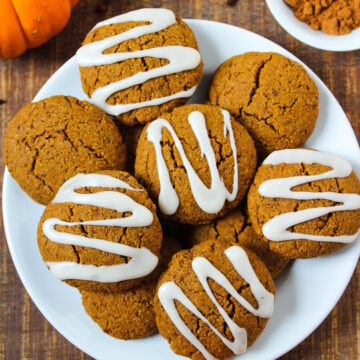 Vegan pumpkin cookies with sugar icing on a white serving plate
