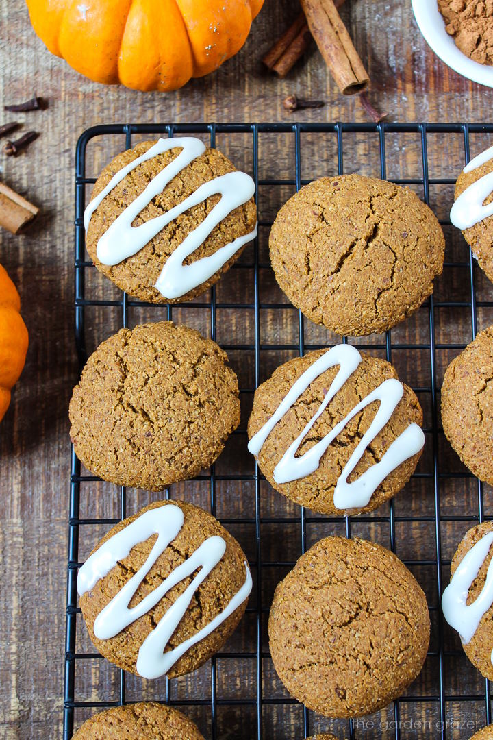 Overhead view of vegan pumpkin cookies on a cooling rack and some frosted with icing