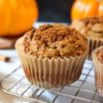 Vegan pumpkin muffin with cinnamon sugar topping on a cooling rack after baking