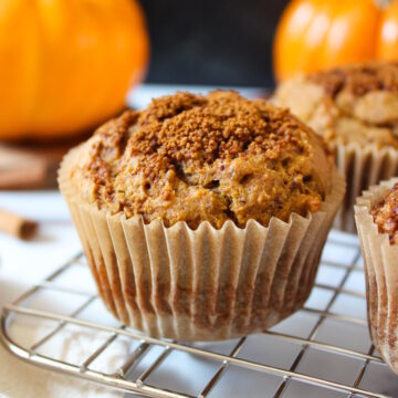 Vegan pumpkin muffin with cinnamon sugar topping on a cooling rack after baking