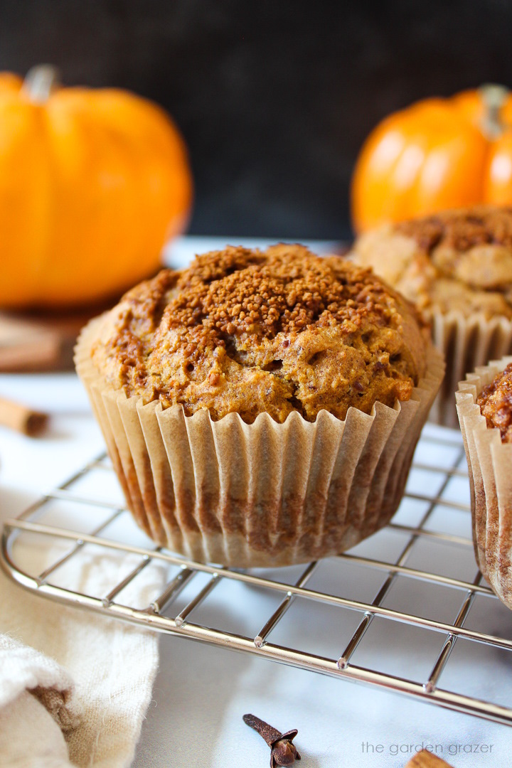 Vegan pumpkin muffin with cinnamon sugar topping on a cooling rack after baking