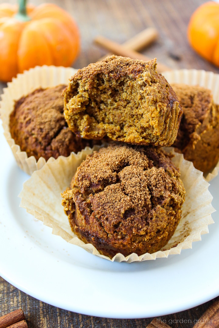Gluten-free vegan pumpkin muffins stacked on a white serving plate