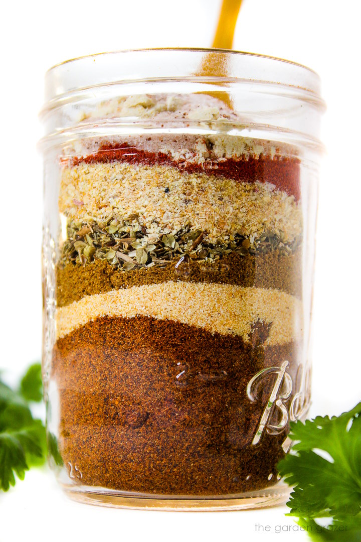 Seasonings layered in a small glass jar before mixing together