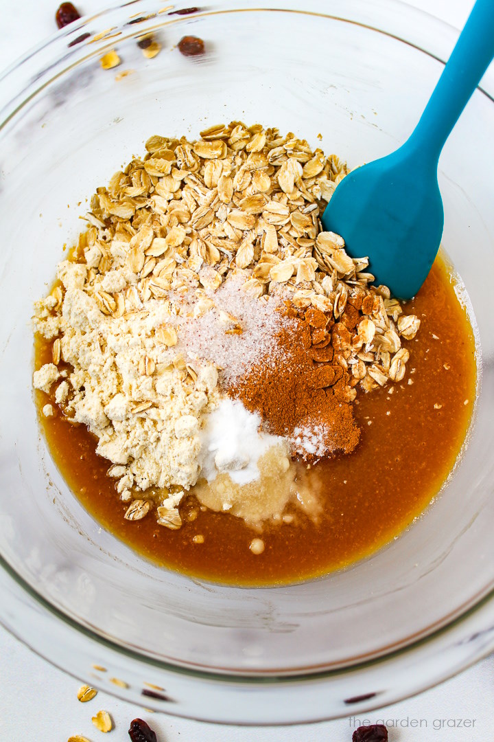 Overhead view of preparing cookie ingredients in a large glass bowl before mixing together