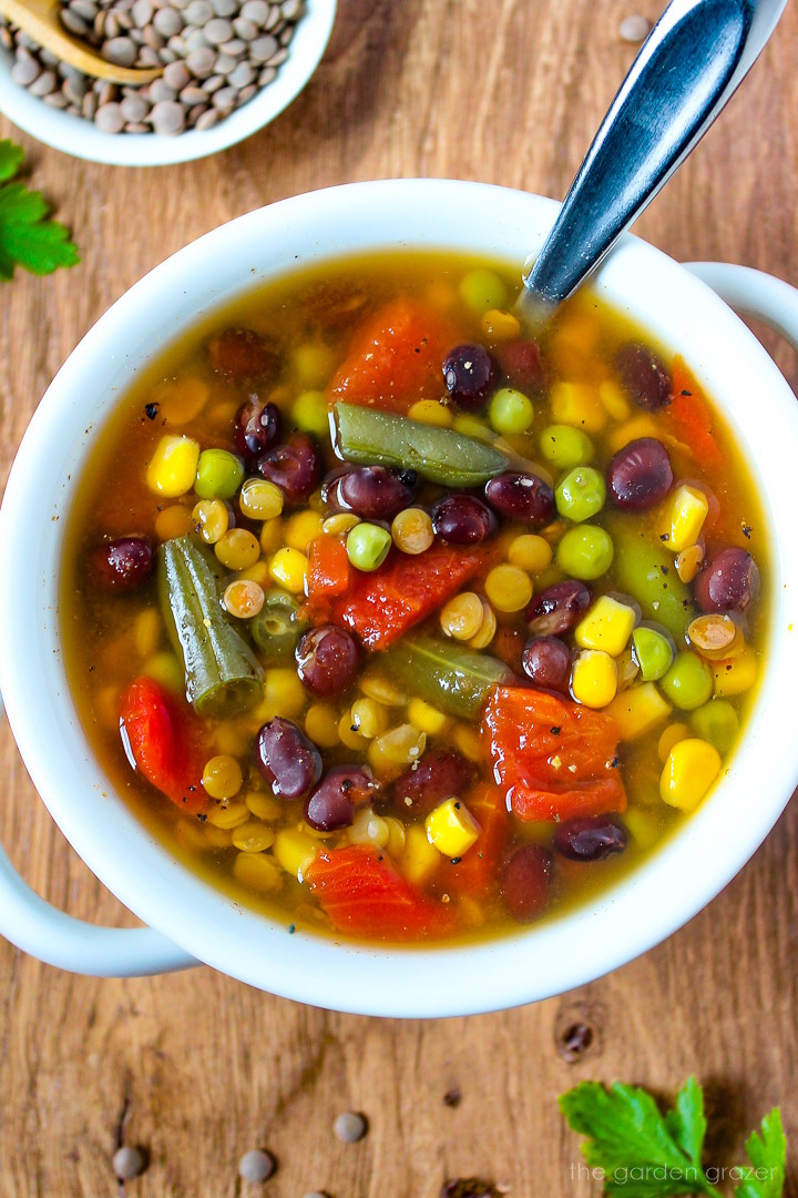 Easy vegan soup with black beans and lentils served in a white bowl with spoon