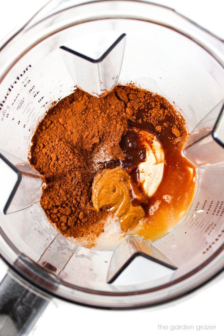 Overhead view of preparing homemade vegan fudgesicle ingredients in a blender before blending together