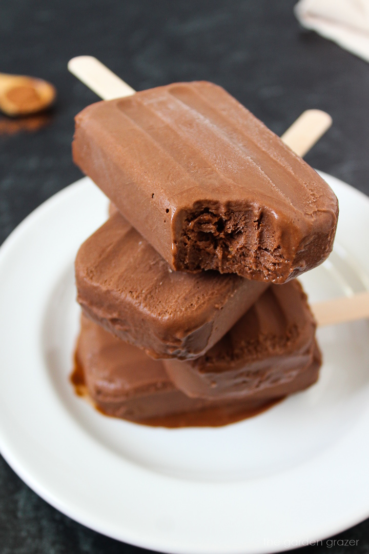 Homemade chocolate vegan fudgesicles stacked on a white plate