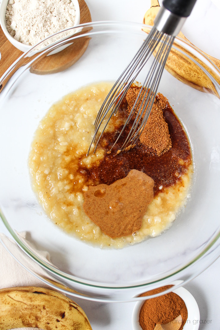 Overhead view of whisking together wet ingredients in a glass mixing bowl
